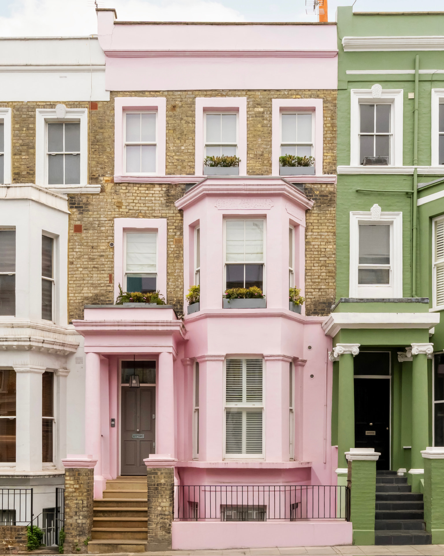 The pink Notting Hill townhouse facade with bay windows