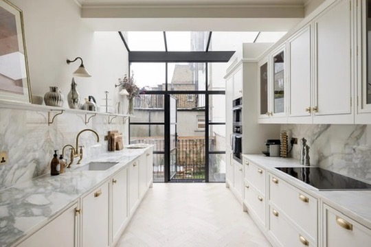 Marble galley kitchen with brass fittings and glazed garden door