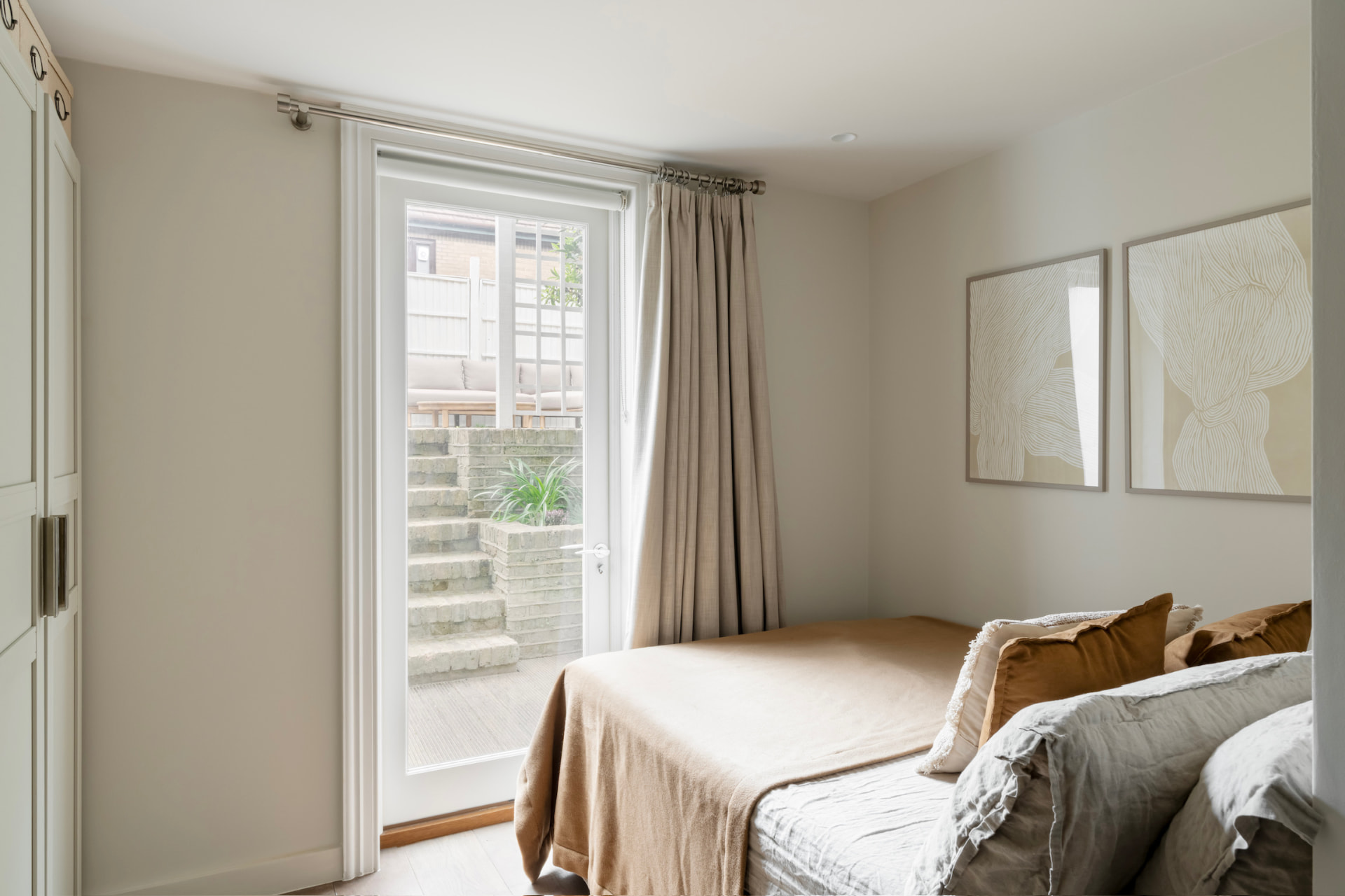 Garden-level bedroom with doors opening onto the brick steps and terrace