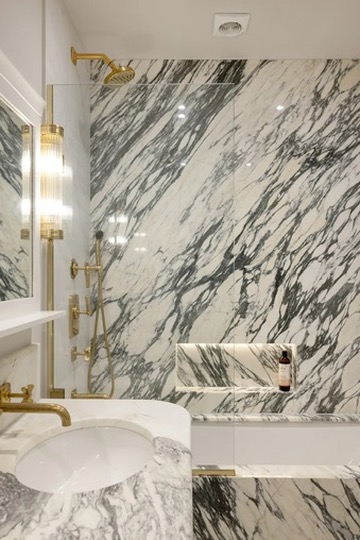 Marble bathroom with brass shower fittings and vanity